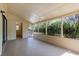 A screened-in porch featuring a concrete floor and multiple framed glass windows offering views of the surrounding yard at 4070 Mcneil Rd, Apopka, FL 32703