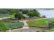 Aerial view showcasing a home with a tennis court, spacious lawn, and waterfront access at 4199 Conway Place Cir, Orlando, FL 32812