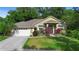 Charming single-story home with a well-manicured lawn, mature landscaping, and attached two-car garage at 4199 Conway Place Cir, Orlando, FL 32812