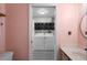 Functional laundry area featuring a washer, dryer, and shelving for storage, seamlessly integrated with a bathroom and providing convenience at 4199 Conway Place Cir, Orlando, FL 32812