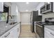 Kitchen features stainless steel appliances, granite countertops, and white cabinets at 451 E 5Th St, Chuluota, FL 32766
