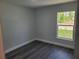 Bright bedroom features a window with natural light and gray wood laminate flooring at 4529 Sw 169Th Pl, Ocala, FL 34473