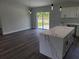Open floor plan with a kitchen island, stainless steel appliances, gray walls and backyard access at 4529 Sw 169Th Pl, Ocala, FL 34473