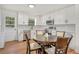 Modern kitchen with white cabinets, stainless steel appliances, and a cozy dining area with stylish lighting at 4922 Huppel Ave, Orlando, FL 32811