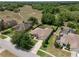 Expansive aerial view of a well-maintained home, boasting a manicured lawn and screened lanai, next to a golf course at 525 Hebrides Ct, Apopka, FL 32712