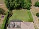 Aerial view of a spacious backyard featuring manicured lawn, privacy hedges, and a screened lanai with outdoor seating at 525 Hebrides Ct, Apopka, FL 32712