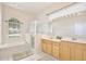 Bright bathroom with double sink vanity, soaking tub, and glass-enclosed shower at 525 Hebrides Ct, Apopka, FL 32712