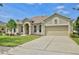 Inviting single-story home with arched entryway, a two-car garage, and well-maintained landscaping at 525 Hebrides Ct, Apopka, FL 32712