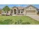 Charming single-story home with a well-manicured lawn, arched windows, and a two-car garage at 525 Hebrides Ct, Apopka, FL 32712
