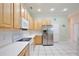 Clean, bright kitchen with stainless steel fridge, wooden cabinets, and white countertops at 525 Hebrides Ct, Apopka, FL 32712