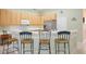 Updated kitchen with stainless steel appliances, light wood cabinets, and breakfast bar seating at 525 Hebrides Ct, Apopka, FL 32712