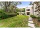 Expansive backyard with a well-maintained lawn, stepping stone pathway, and surrounding greenery, perfect for outdoor activities at 608 E Club Cir, Longwood, FL 32779