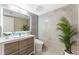Modern bathroom with gray tile, wood vanity, and backlit mirror at 608 E Club Cir, Longwood, FL 32779