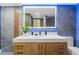 Modern bathroom with a wood vanity, white countertop, and a large illuminated mirror with blue perimeter lighting at 608 E Club Cir, Longwood, FL 32779