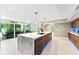 An open-concept kitchen showcases a marble island, modern appliances, and sliding doors to the outdoor dining at 608 E Club Cir, Longwood, FL 32779