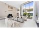 Bright living room boasts high ceilings, neutral walls, tile floors, and a wall of windows overlooking lush landscaping at 608 E Club Cir, Longwood, FL 32779