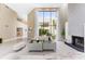 Bright living room boasts high ceilings, fireplace, and a wall of windows overlooking lush greenery at 608 E Club Cir, Longwood, FL 32779