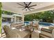 Inviting covered outdoor living space with ceiling fan, comfortable seating, and serene pool views at 608 E Club Cir, Longwood, FL 32779