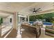 Outdoor patio area with comfortable seating, ceiling fan, overlooking the swimming pool and lush greenery at 608 E Club Cir, Longwood, FL 32779