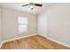Bedroom with wood-look floors, ceiling fan, and window with blinds, creating a bright space at 6434 S Goldenrod Rd # 17B, Orlando, FL 32822