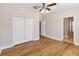 Bedroom featuring wood-look floors, ceiling fan, bi-fold doors, and light-colored walls at 6434 S Goldenrod Rd # 17B, Orlando, FL 32822