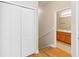 Hallway featuring wooden floors and bi-fold doors, leading to bathroom with wooden cabinets at 6434 S Goldenrod Rd # 17B, Orlando, FL 32822
