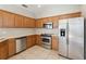 The kitchen features stainless steel appliances, wooden cabinetry, and tiled flooring for easy maintenance at 6434 S Goldenrod Rd # 17B, Orlando, FL 32822