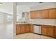 Well-lit kitchen featuring stainless steel dishwasher and light wood cabinetry, open to the living area at 6434 S Goldenrod Rd # 17B, Orlando, FL 32822