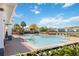 Community pool area featuring lounge chairs, a nearby lake, and greenery at 6434 S Goldenrod Rd # 17B, Orlando, FL 32822