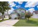 Inviting two-story home with a well-manicured lawn, concrete driveway, and attached garage at 645 Upperriver Ct, Orlando, FL 32828