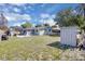 Wide backyard showcases the home's exterior, storage shed, solar panels, and a grassy area perfect for to play at 6464 Inca St, Orlando, FL 32807