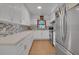Modern kitchen featuring stainless steel appliances, white cabinets, and stylish backsplash at 6464 Inca St, Orlando, FL 32807