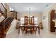 Elegant dining room with a large table, china cabinet, and staircase with shutters, bathed in natural light at 6857 Dolce St, Orlando, FL 32819