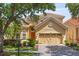 Charming two-story home with a beautiful red-tile roof, brick paver driveway, and lush landscaping at 6857 Dolce St, Orlando, FL 32819
