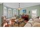 Cozy living room featuring large windows with shutters, comfortable seating, and elegant decor at 6857 Dolce St, Orlando, FL 32819