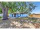 Rear view of the home displaying a covered patio and large backyard area with trees at 7507 Duo Lakes Dr, Orlando, FL 32810