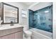 Bathroom featuring blue tiled bath tub, modern vanity, and a window at 7507 Duo Lakes Dr, Orlando, FL 32810