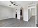 Spacious bedroom with light gray walls, ceiling fan, and several entry doors at 7507 Duo Lakes Dr, Orlando, FL 32810
