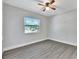 Bedroom featuring a ceiling fan, natural light and gray wood laminate floors at 7507 Duo Lakes Dr, Orlando, FL 32810