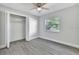 Clean bedroom with wood laminate floors, a ceiling fan, and a large closet at 7507 Duo Lakes Dr, Orlando, FL 32810