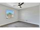 Clean bedroom features a window with backyard view and ceiling fan at 7507 Duo Lakes Dr, Orlando, FL 32810
