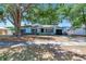 Charming single-story home featuring an attached garage, mature tree, and brick accents at 7507 Duo Lakes Dr, Orlando, FL 32810