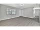 Open living room with light gray walls, wood laminate floors, and large window at 7507 Duo Lakes Dr, Orlando, FL 32810