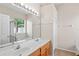 Bright bathroom featuring double sinks, white countertops and vanity, with natural light from the window and neutral walls at 802 Pickfair Ter, Lake Mary, FL 32746