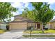 Two-story home featuring a well-manicured lawn, mature shade trees, and attached two-car garage at 802 Pickfair Ter, Lake Mary, FL 32746