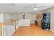 Open loft showcasing a study area and a retro arcade game, alongside hardwood floors, a ceiling fan, and natural light at 802 Pickfair Ter, Lake Mary, FL 32746