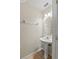 Small half-bathroom featuring a white pedestal sink, oval mirror, simple lighting, and a neutral color scheme at 802 Pickfair Ter, Lake Mary, FL 32746