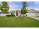 Charming single-story home with a well-maintained lawn and inviting red double door entrance and neutral paint at 8398 Split Creek Cir, Lakeland, FL 33809
