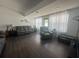 Spacious living room featuring neutral walls and dark wood floors, illuminated by natural light from large windows at 8398 Split Creek Cir, Lakeland, FL 33809