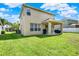 Spacious backyard with well-maintained lawn, and a covered patio, perfect for entertaining or relaxing outdoors at 8448 Greenbank Blvd, Windermere, FL 34786